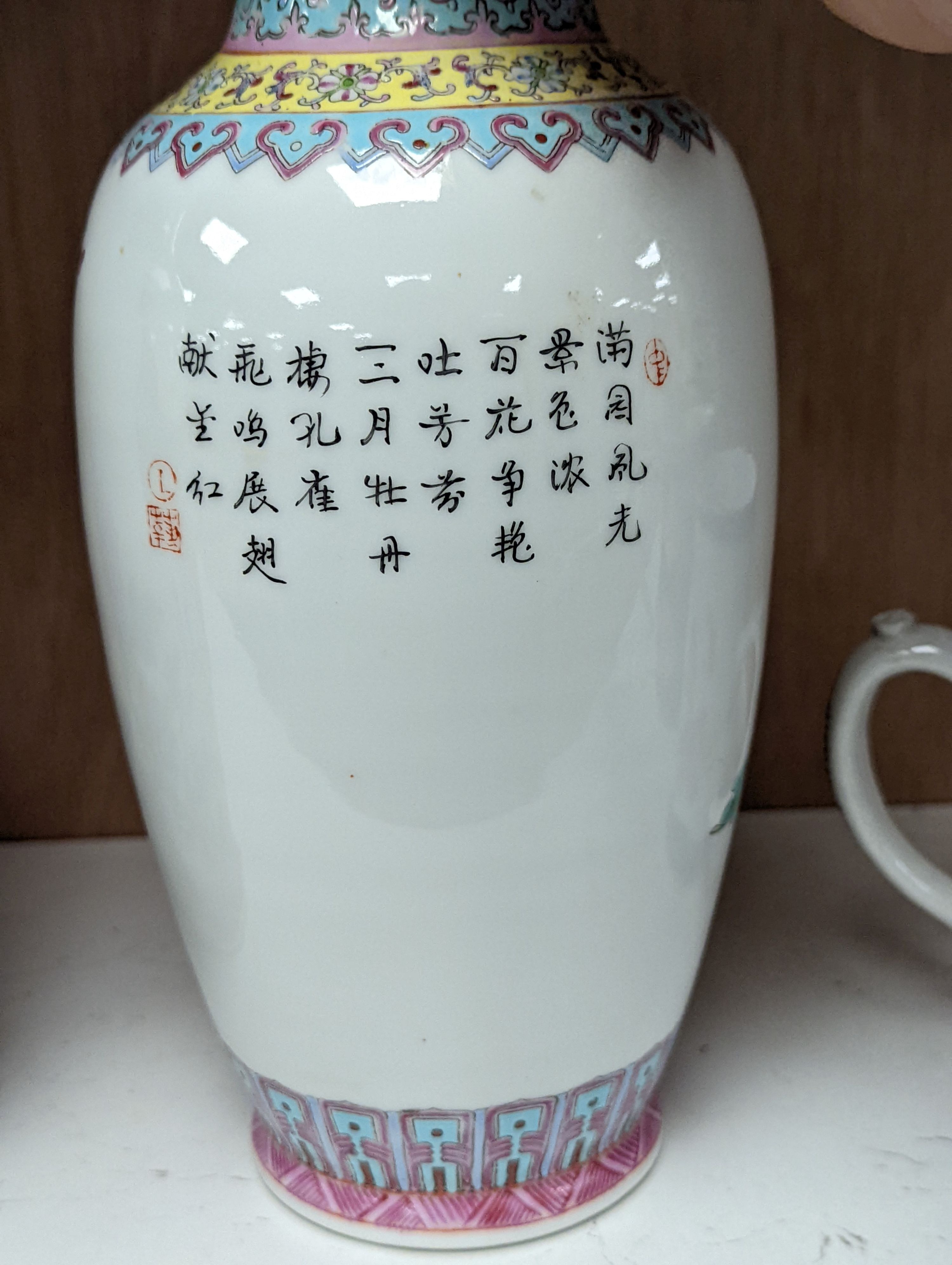 A pair of Chinese famille rose vases decorated with peacocks, 31cm